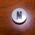 INSERT, BUTTON, 7/8 DIA., WHITE, MARKED M IN BLACK ARMOR # 11133-01