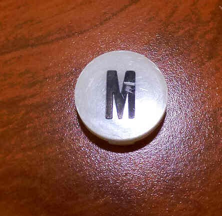 INSERT, BUTTON, 7/8 DIA., WHITE, MARKED M IN BLACK ARMOR # 11133-01