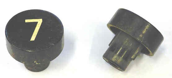 BUTTON, BLACK, MARKED # 7, 1 DIAMETER OTIS # 323BD1-7