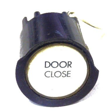 PUSHBUTTON, BLACK, ROUND, WHITE INSERT, MARKED DOOR CLOSE  US # 167-03011-100